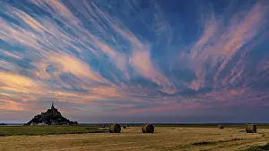 Church: Mont Saint-Michel at sunset with dramatic sky and straw bales