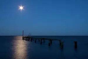 Jettys: Moon over sea - long exposure image of the moon