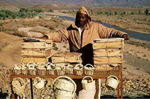 Selling: MOROCCO - Berber selling souvenirs and dates