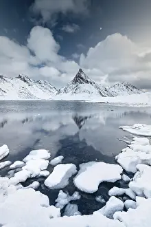 Lofoten: Mount Volandstinden reflected in fjord, snow-covered