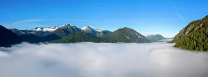 Protrude: Mountains rising out of high fog over Lake Sylvensteinsee