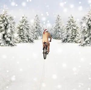 Bicycles: Naked male in Christmas hat cycling through winter scene