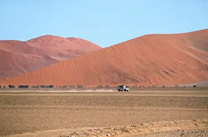 Flanked: Namibia - a landrover drives through the valley