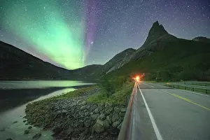 Starry: Night shot of (Aurora borealis) a road with illuminated