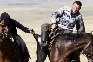 Peoples: Nomadic horsemen playing in a meadow in Kyrgyzstan