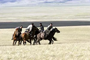 Peoples: Nomadic horsemen playing in a meadow in Kyrgyzstan