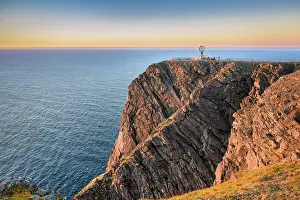Finnmark: North Cape cliff with steel globe in the light of