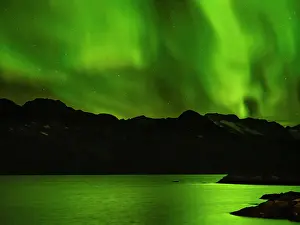 Strait: Northern lights over Angmagssalik Fjord near settlement