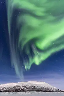 Spectacle: Northern Lights (Aurora Borealis) over snowy mountains