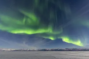 Spectacle: Northern Lights (Aurora Borealis) over snowy mountains