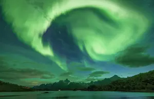 Situation: Northern lights over the fjord, behind them rugged