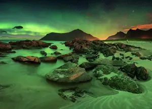 Situation: Northern lights over rocky beach, in the back tiny