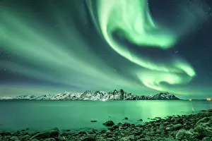 Situation: Northern lights over the sea and snow-covered mountains