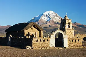 Volcanos: An old Andean church at sunrise in front of volcanos Parina
