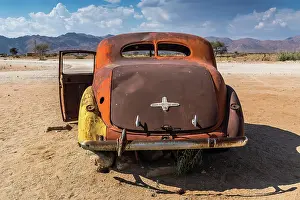 300517: Old car wreck in sand, vintage car, Hudson, chassis