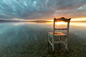 Constance: Old wooden chair in the water at cloudy sky and