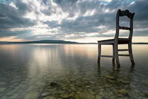 Constance: Old wooden chair in water with cloudy sky, Lake