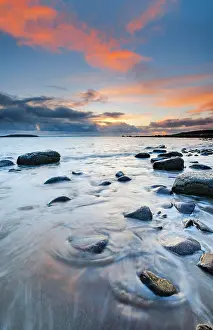 Round: Orange coloured cloudy sky at sunset on a sandy