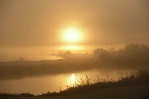 Beacon: Overview of misty IJssel River and its floodplains at sunris
