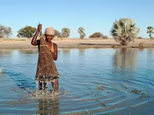 Hyphaene: Owambo girl fishing in a shallow pool (oshana)