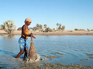 Hyphaene: Owambo girl fishing in a shallow pool (oshana)