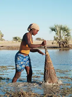 Hyphaene: Owambo girl fishing in a shallow pool (oshana)