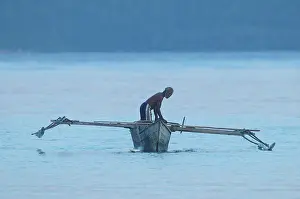 Barat: Papua man in traditional fishing boat with outriggers