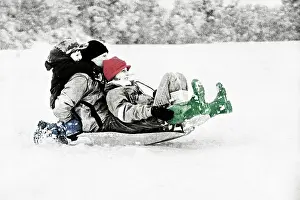 Sledging: Parents and children sledging in deep snow on slopes