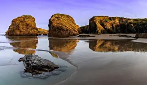Ribadeo: A peaceful sunset on a sandy beach with tidal pools