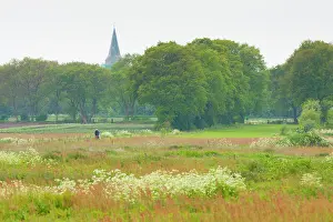 Cycling: People cycling through colorfull spring landscape with churc