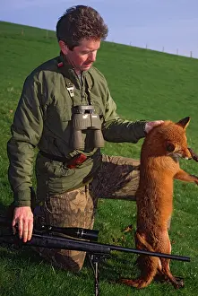 Holds: Pest Control: kneeling rifleman holds dead fox