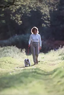 Owner: POLISH LOWLAND DOG - puppy on lead being walked by woman