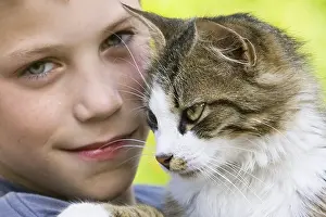 Wheedling: Portrait of a boy with a cat