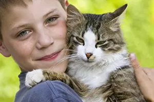 Wheedling: Portrait of a boy with a cat