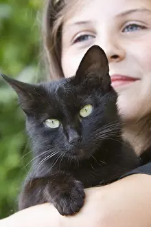 Wheedling: Portrait of a girl with a black cat