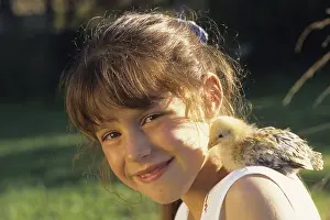 Smiles: Portrait of a young girl carrying a fledging on her shoulder