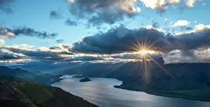 Wanaka: Last rays of sun shining through cloudy sky, view