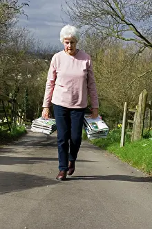 Bundles: Recycling - woman carrying bundles of magazines