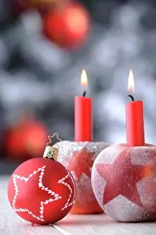 Burning: Red Christmas bauble with apples and candles in