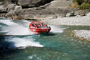 Queenstown: Red Shotover jet boat skimming through Shotover