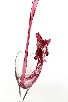 Alcoholic: Red wine being poured a into glass