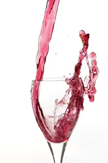 Alcoholic: Red wine being poured a into glass