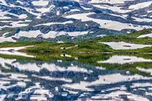 Fell: Reflection of partly snow-covered mountains in Lake