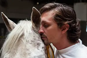 Speaking: Riding instructor whispering in the ear of a horse