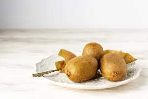 Ripe: Ripe kiwis lie on a white ceramic plate