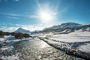 Flows: River flows through snowy valley in winter with