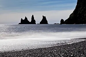 Butte: Rock spikes Reynisdrangar with surf on the beach