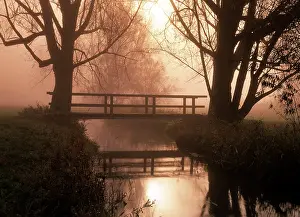 Spanning: Romantic bridge spanning brook in morning mist