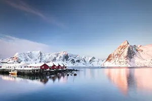 Cabin: Rorbuer huts of Hamnoy at sunrise, behind snow-covered