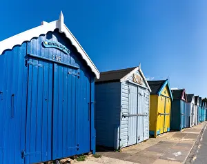 Cottages: Row of colorful wooden beach cottages on the ocean